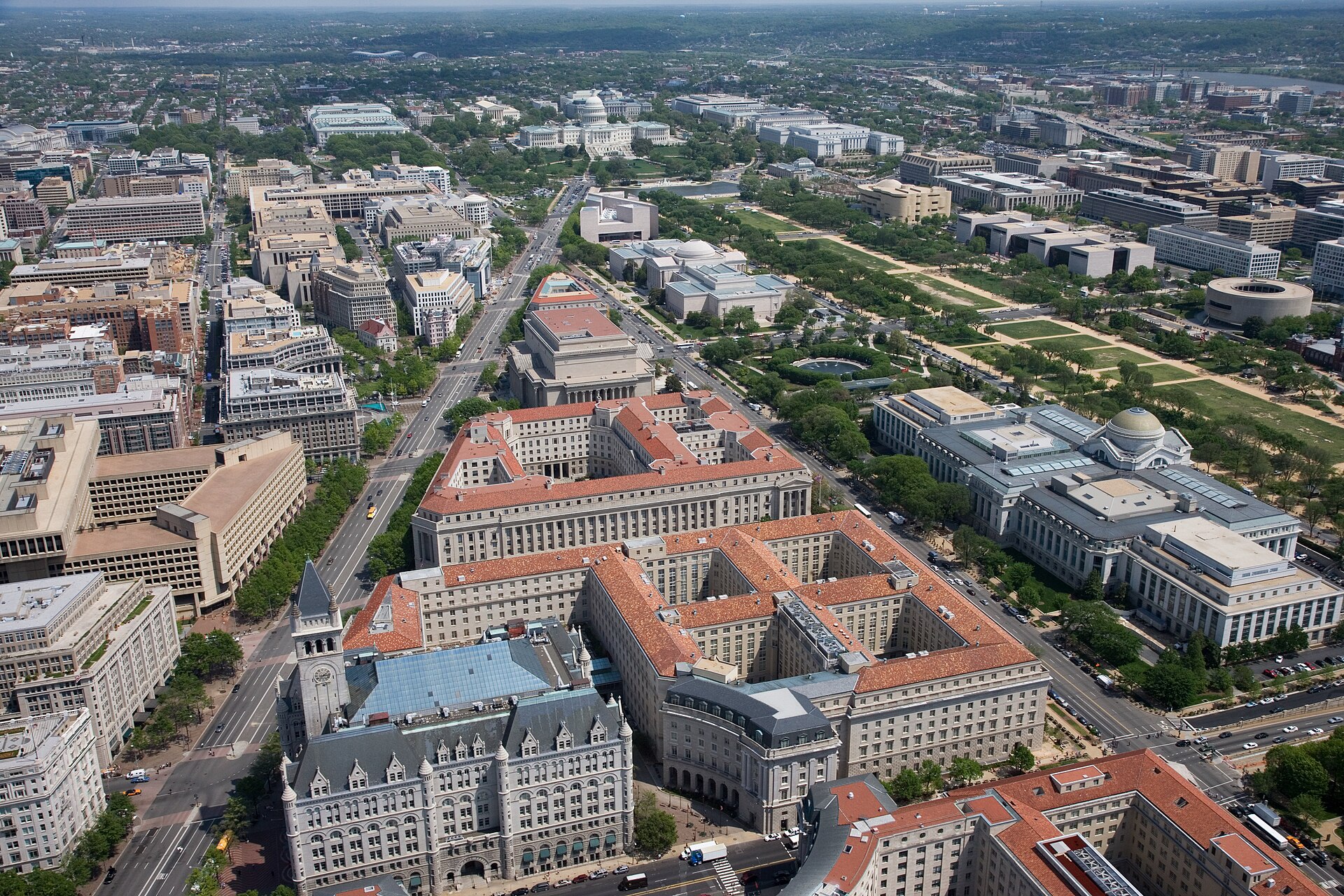 Aerial view of Pennsylvania Avenue (left) and the Federal Triangle (center) , facing east towards the United States Capitol in Washington, D.C. Visible landmarks include the Old Po