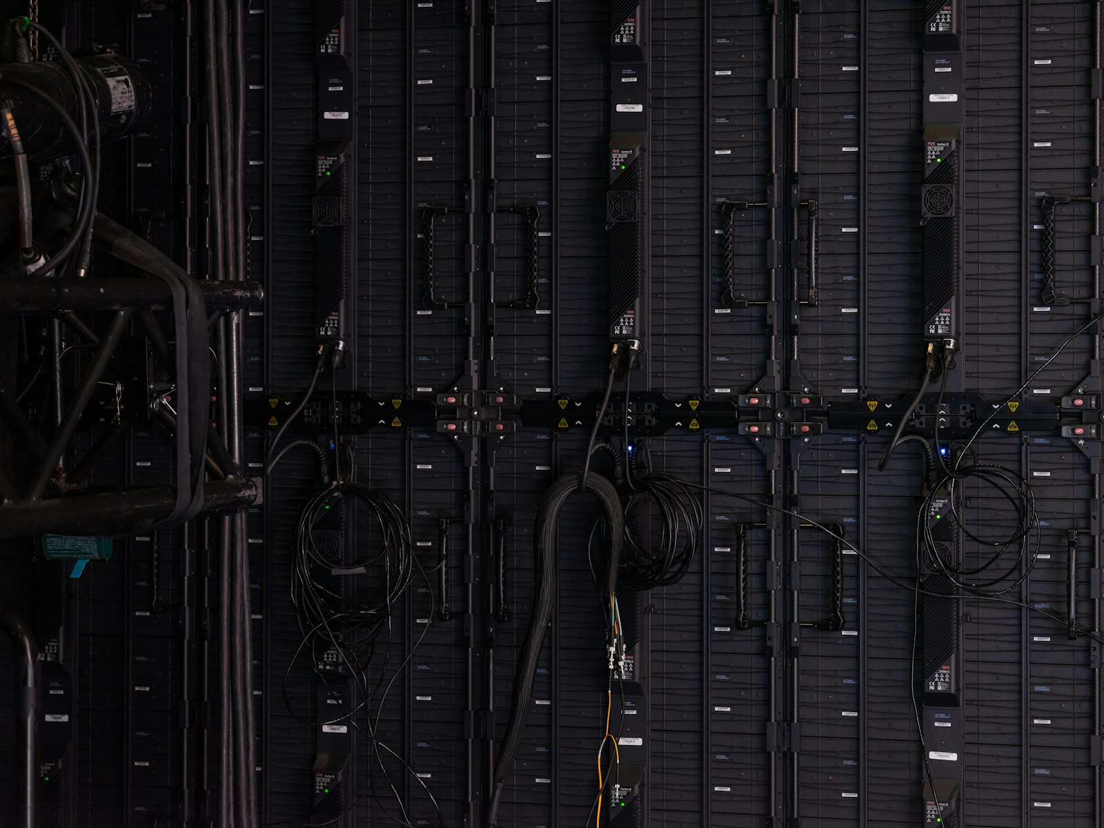 Black cables and wires connected to the back of modular LED display panels
